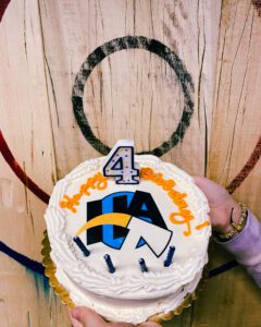 Anniversary cake in front of an axe throwing target