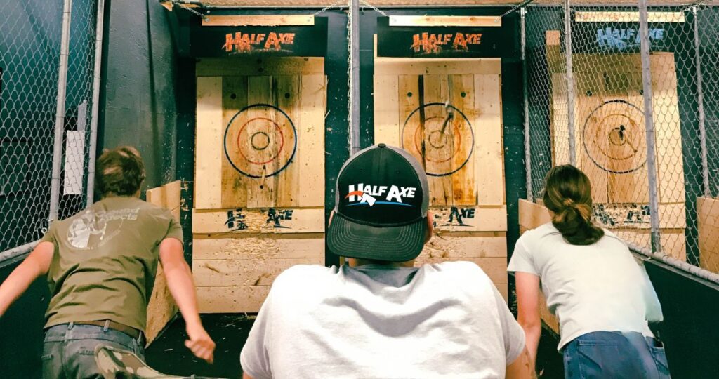 a group of friends in front of targets at half axe, having fun axe throwing